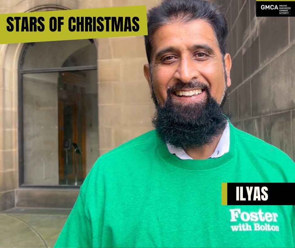 Ilyas standing outside a public building and smiling at the camera