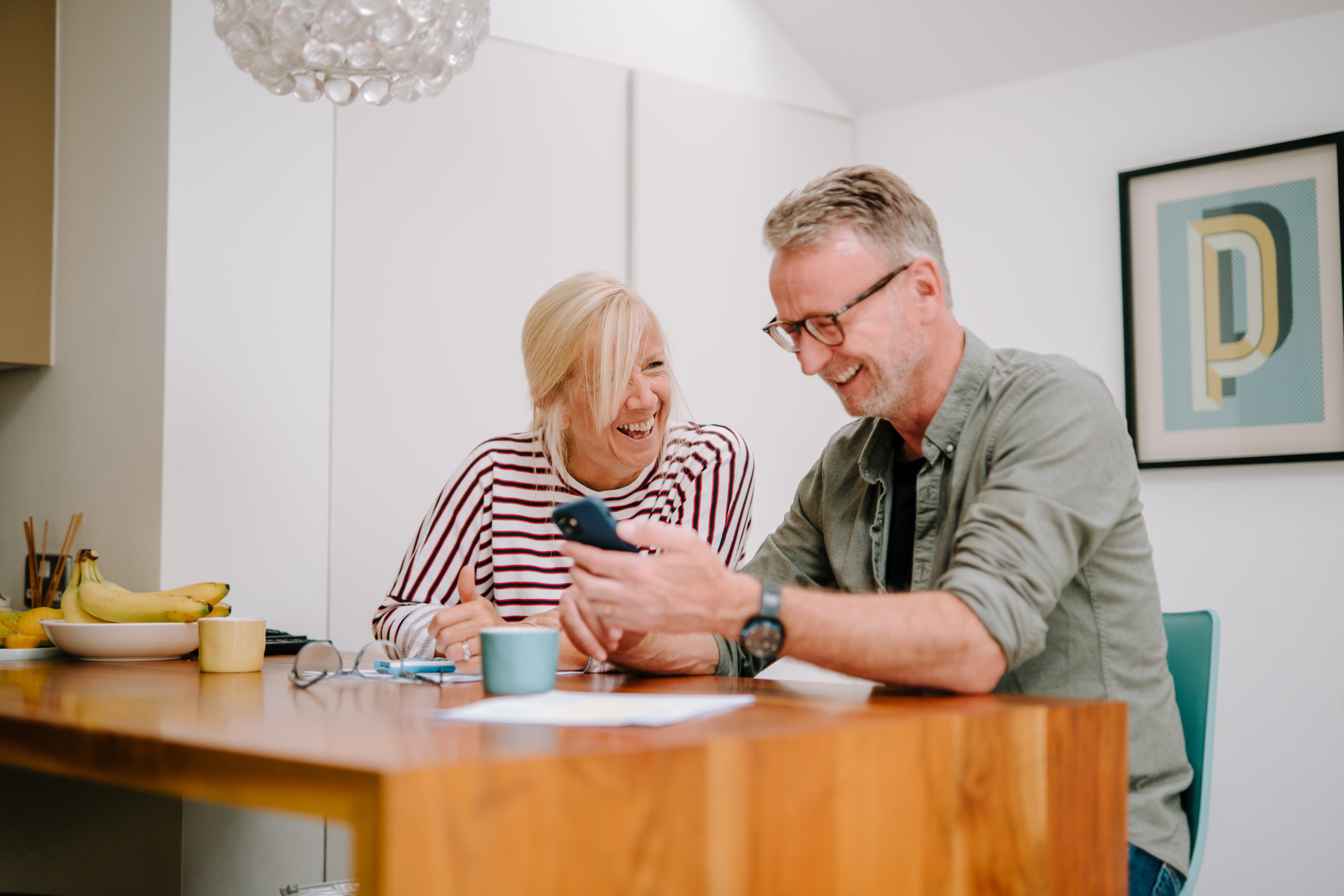 Happy mature couple reading a message on a mobile phone