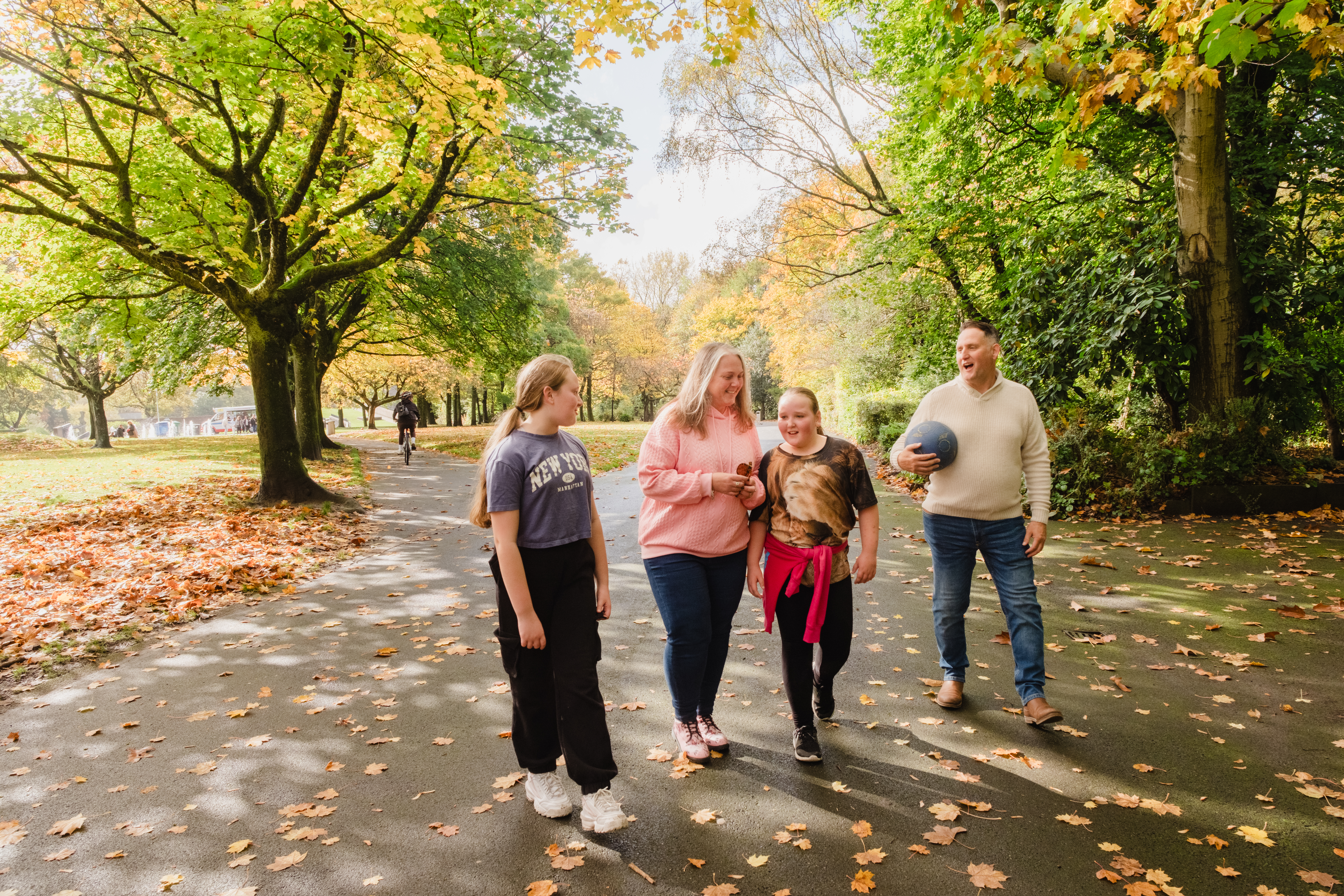 Foster family walking through a park 