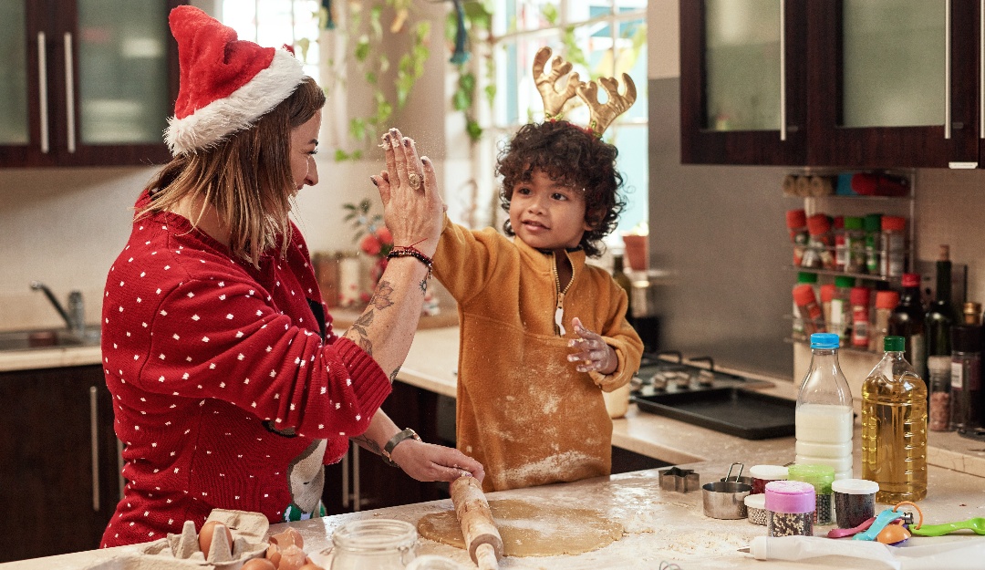 Mother and son high five while baking at Christmas