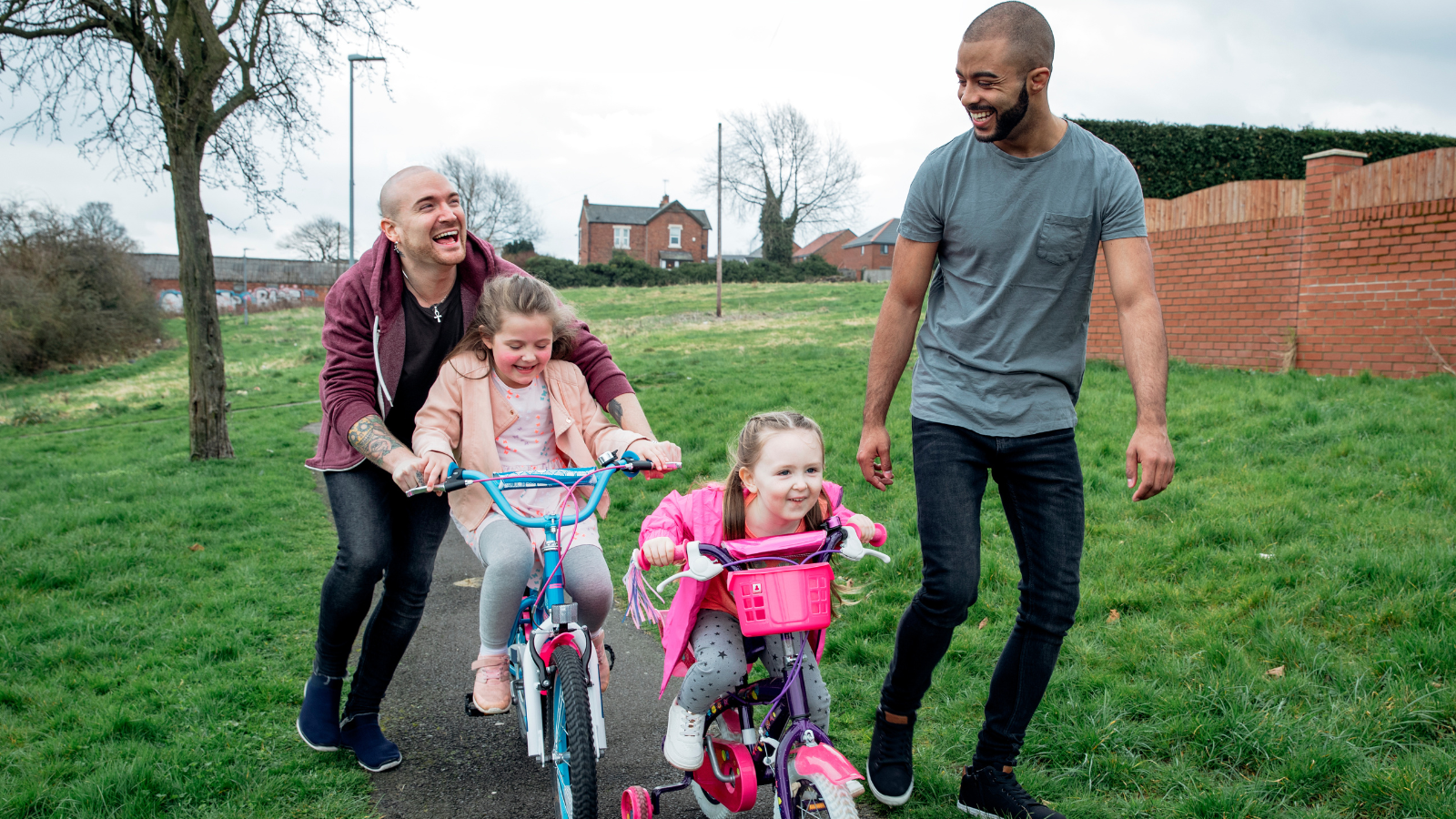 two men and two children playing in a park